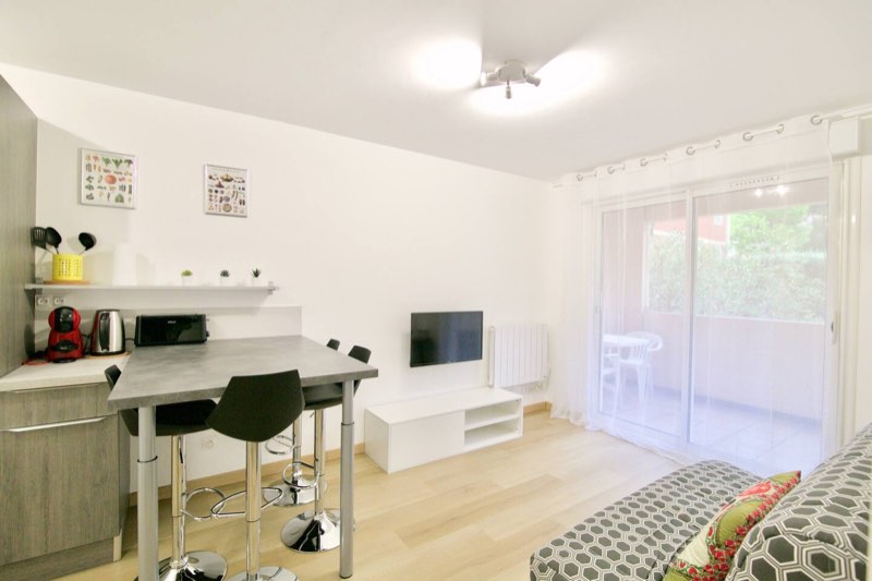 Bright living room with open-plan kitchen and glass doors onto the terrace, Tamaris T2 Villa Massada